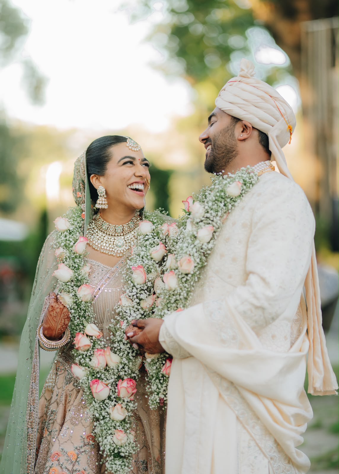 Ankshita and Rohit laughing in their wedding garlands