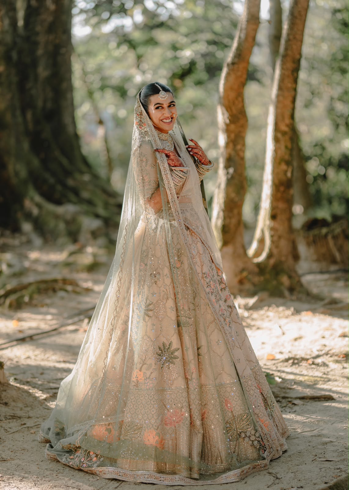 Ankshita in her pale bridal lehenga among the trees