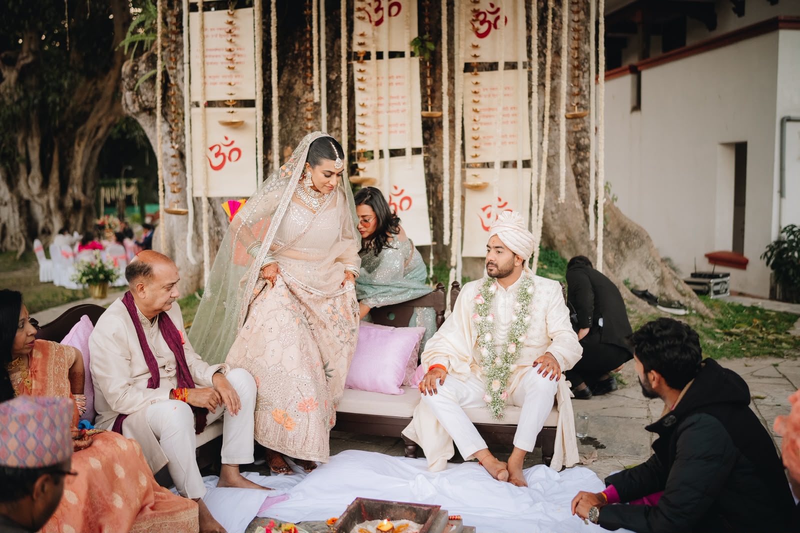 Ankshita and Rohit seated at the ceremony under the old tree