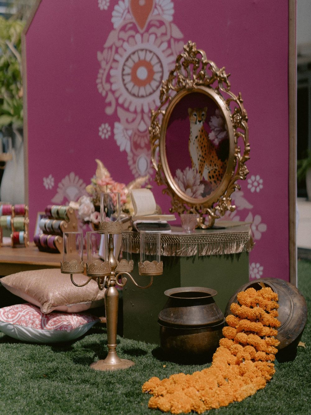 A gilded mirror framing a leopard, with marigolds spilling from a brass pot