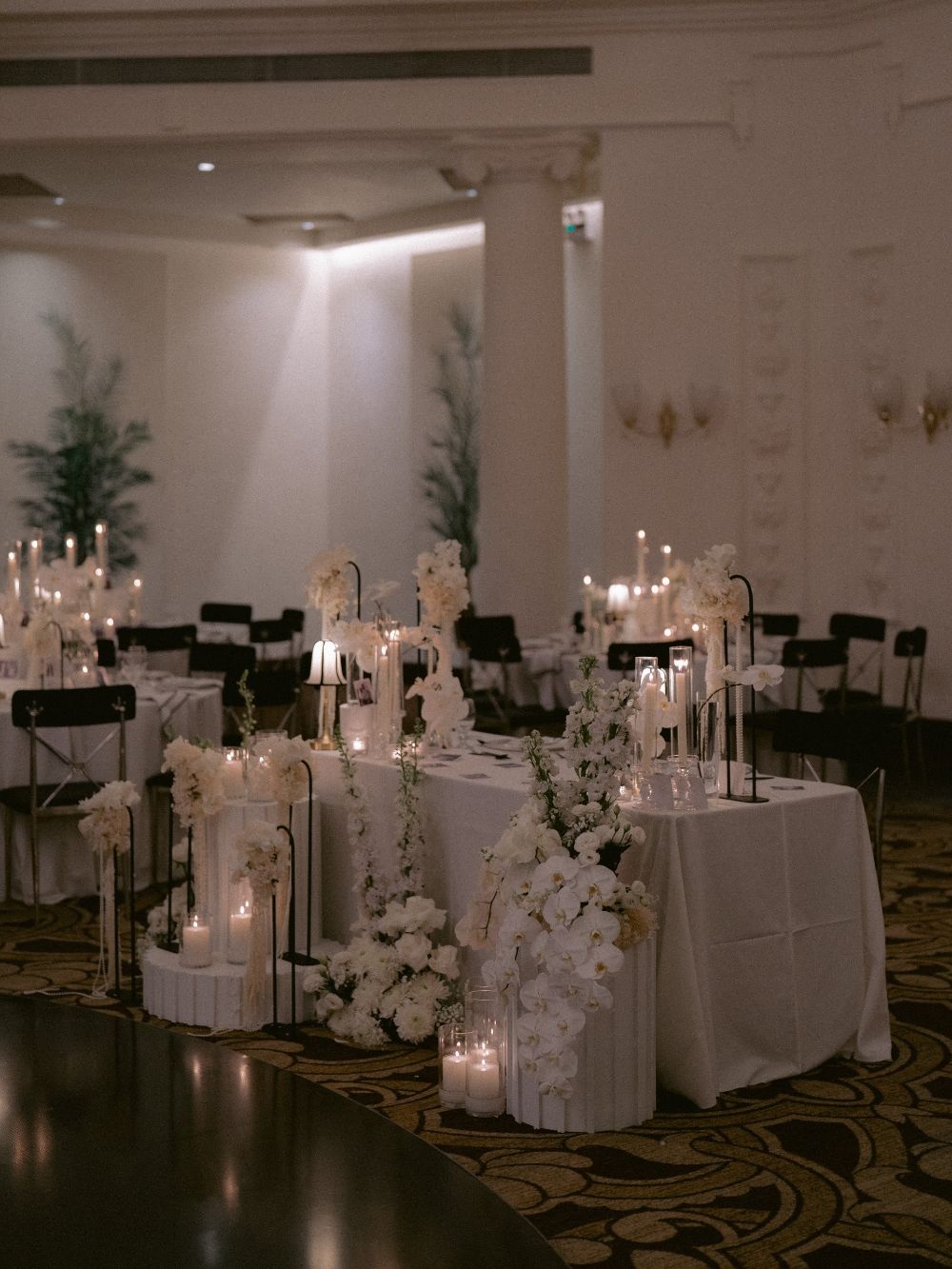 The reception room in black and white, with white flowers and candles on the tables