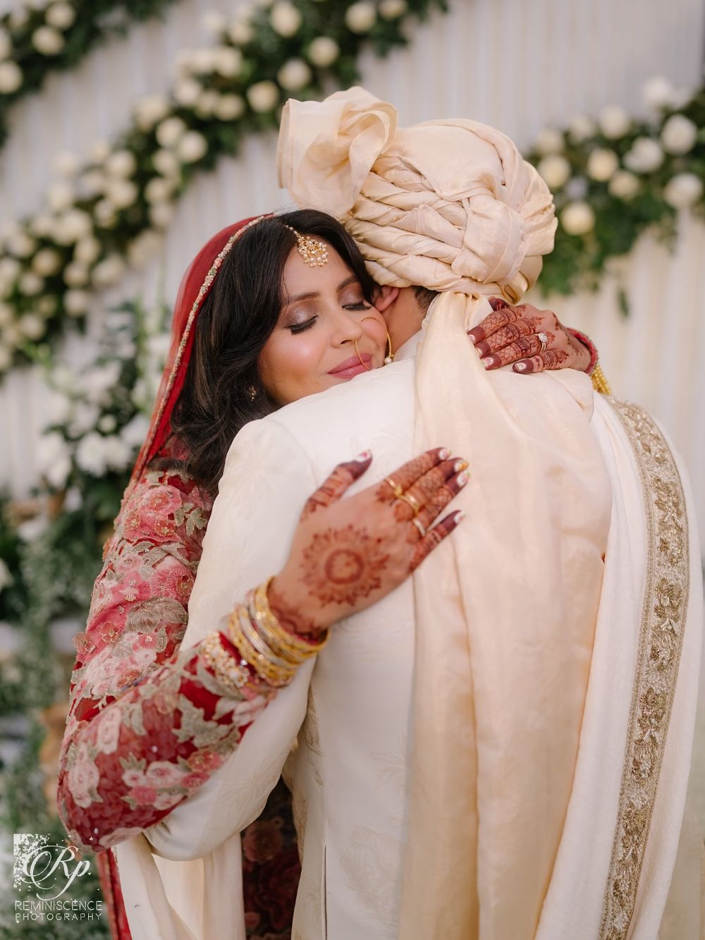 Salsabil in a red dupatta embracing her husband in an ivory turban