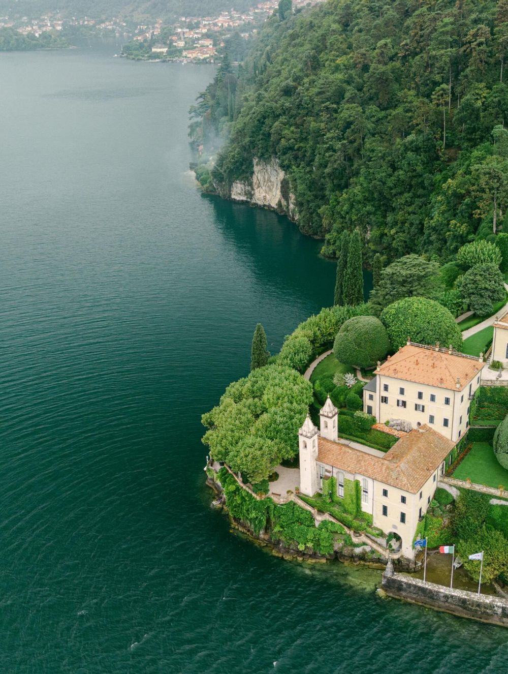 A villa and its gardens on a wooded point of Lake Como, seen from above