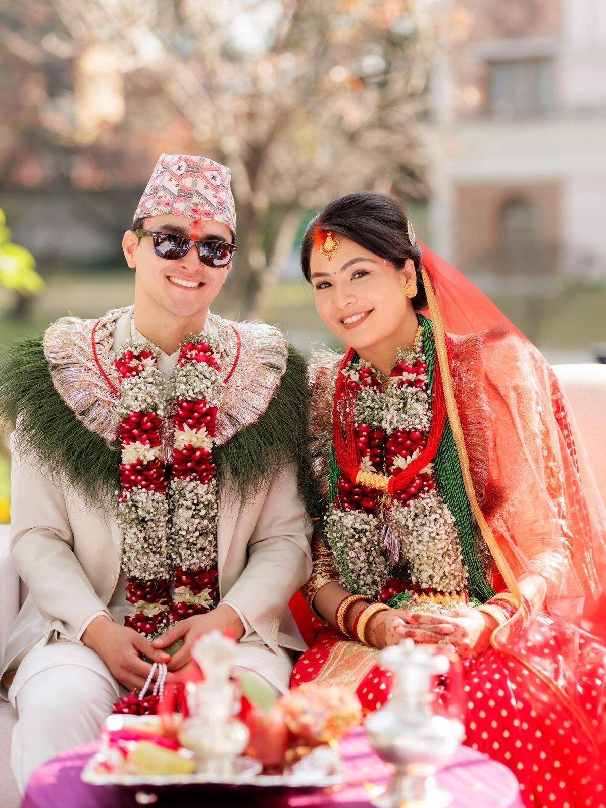 Ushma and her husband seated at the wedding in garlands